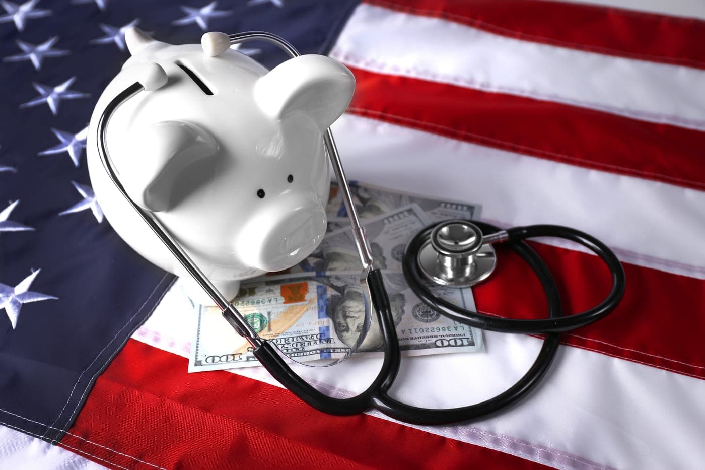 A stethoscope and cash resting on a U.S. flag