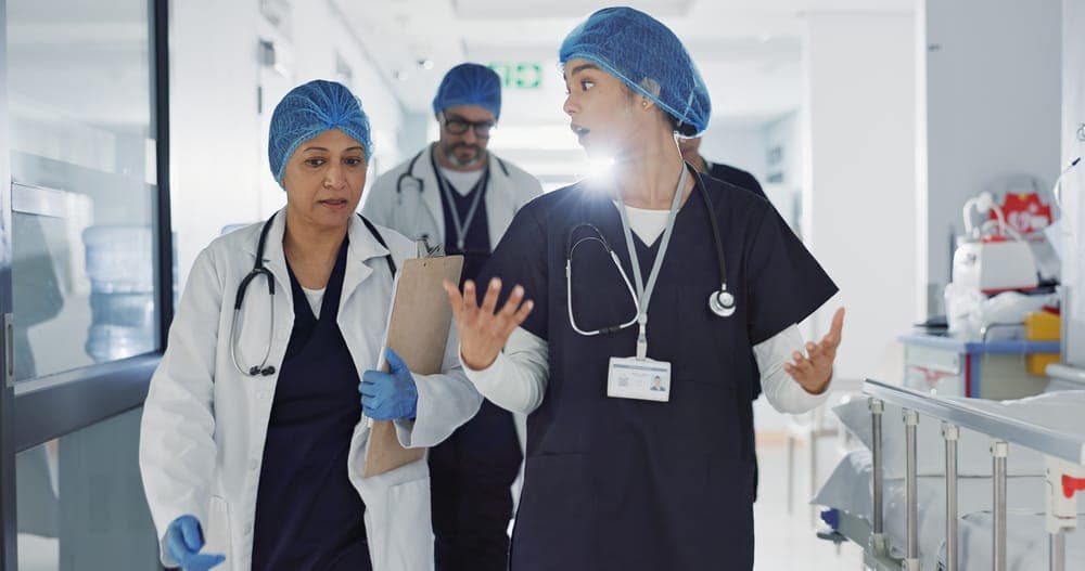 Healthcare professionals conferring in a hospital corridor